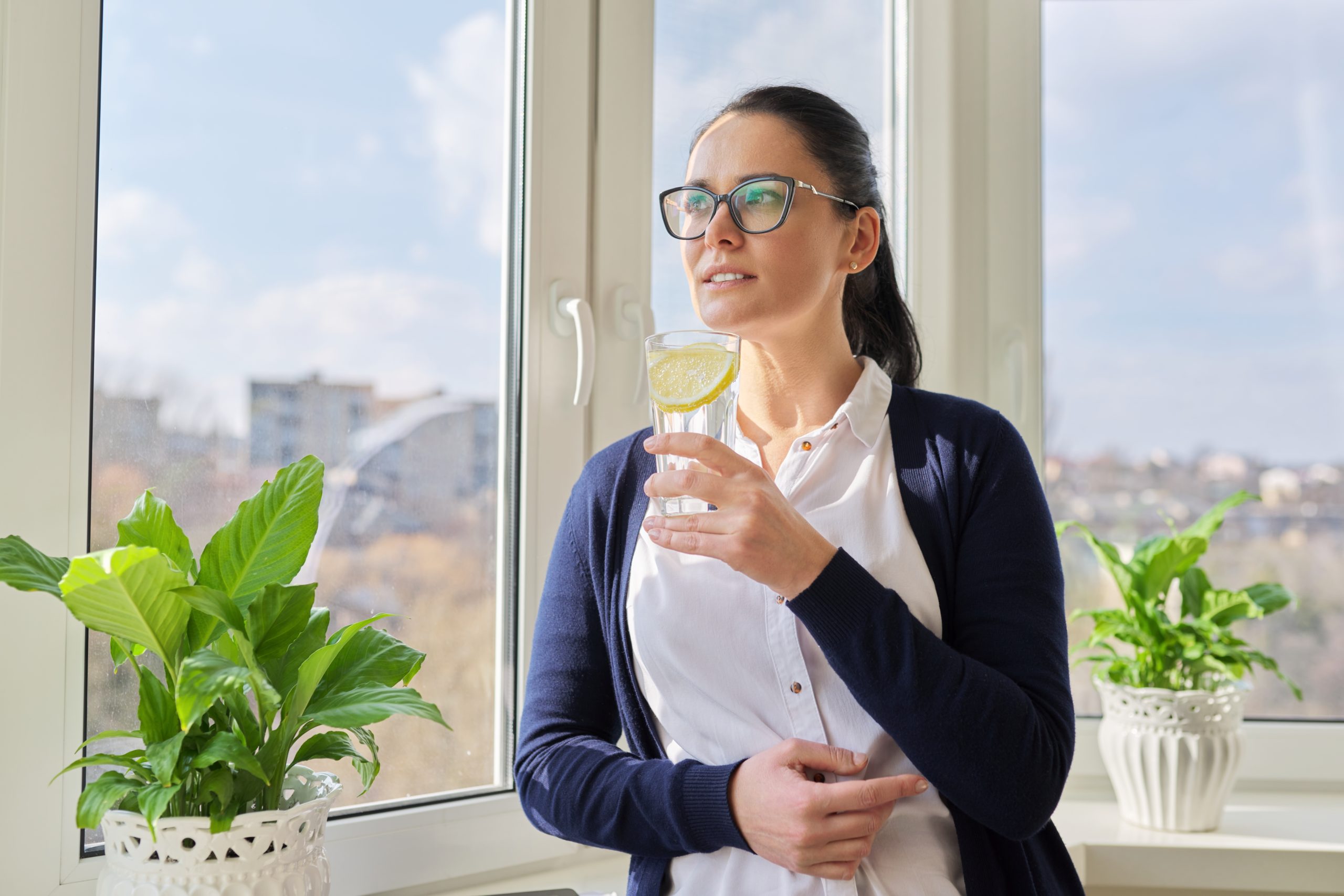 woman drinking treated water in kitchen