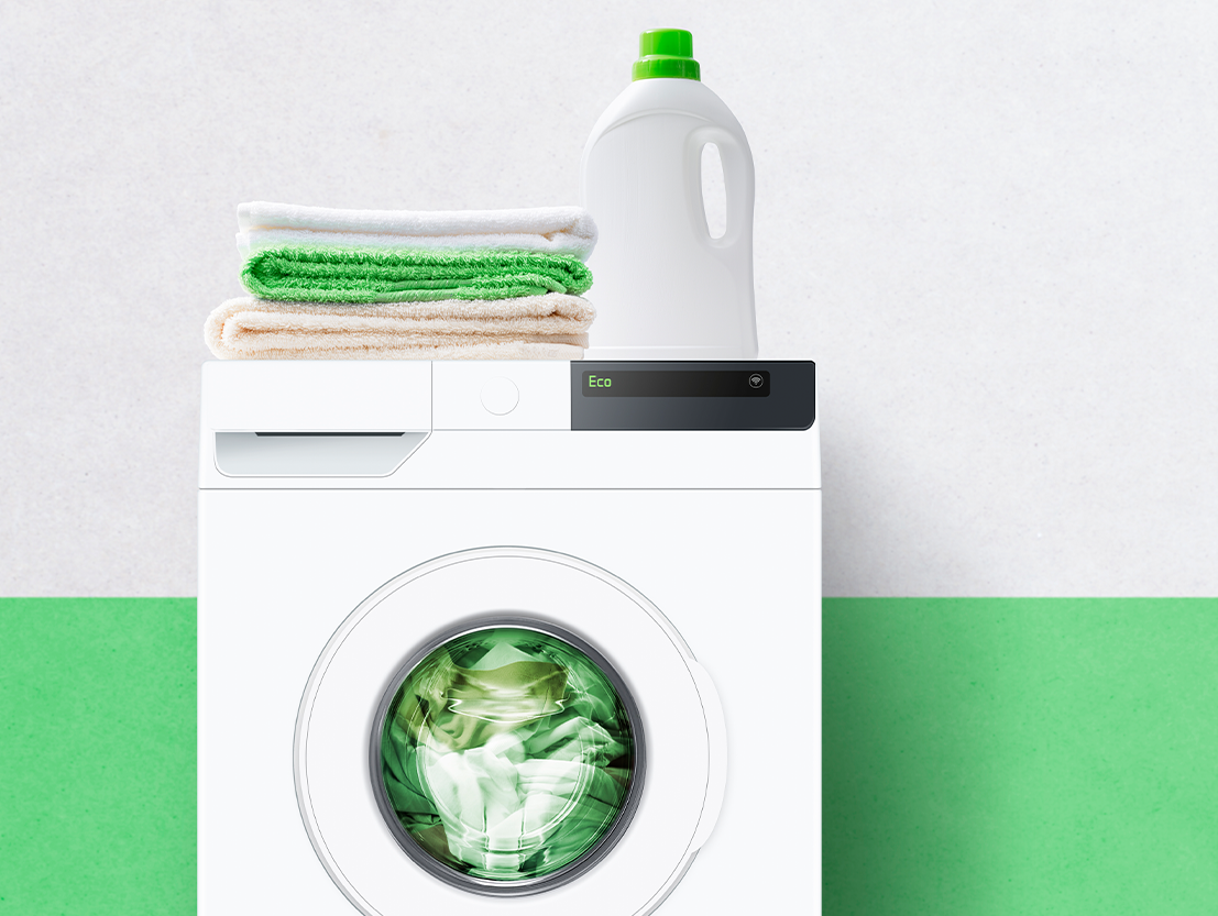 green laundry room with towels, washing machine, and laundry detergent