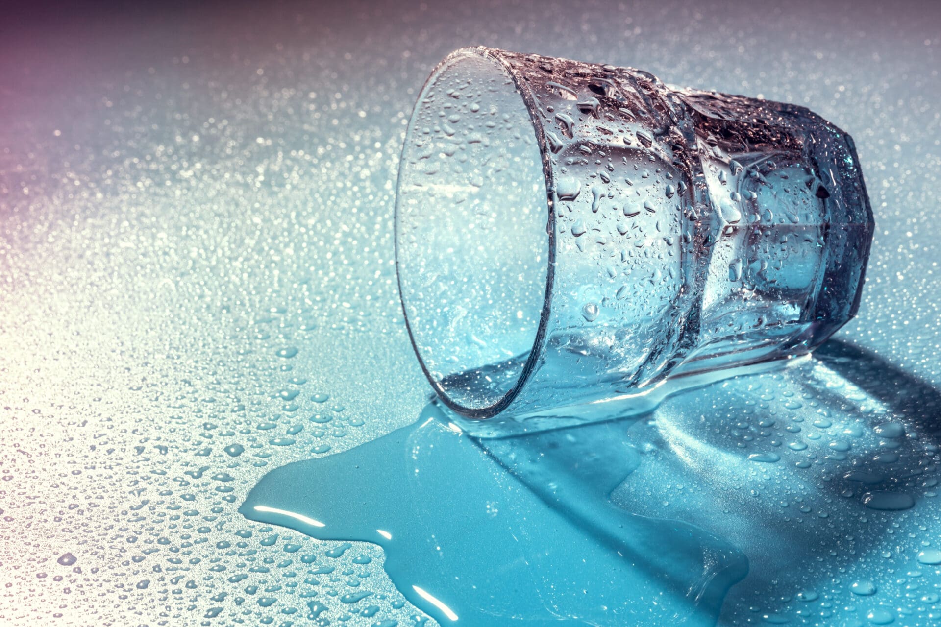 Glass of water Tipped over glass with water spilling