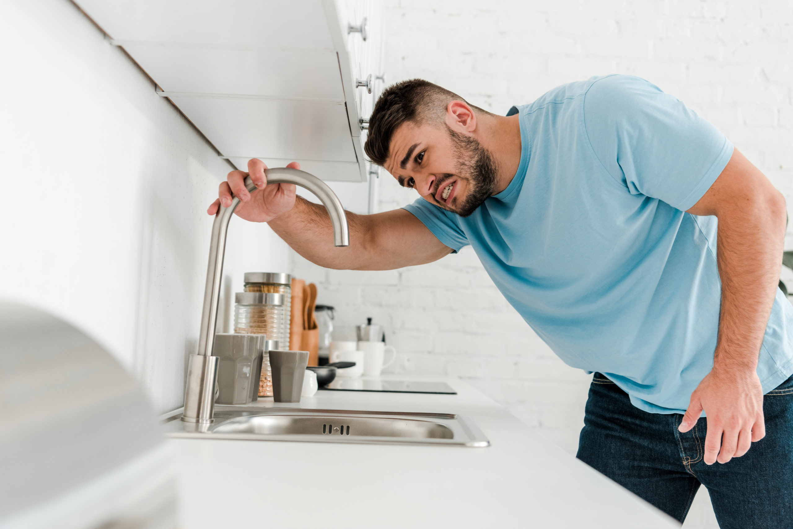selective focus of stressed man looking at sink in modern kitchen